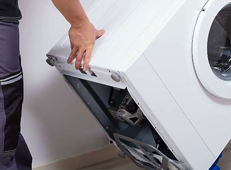 Person moving a Whirlpool® Front Load Washer