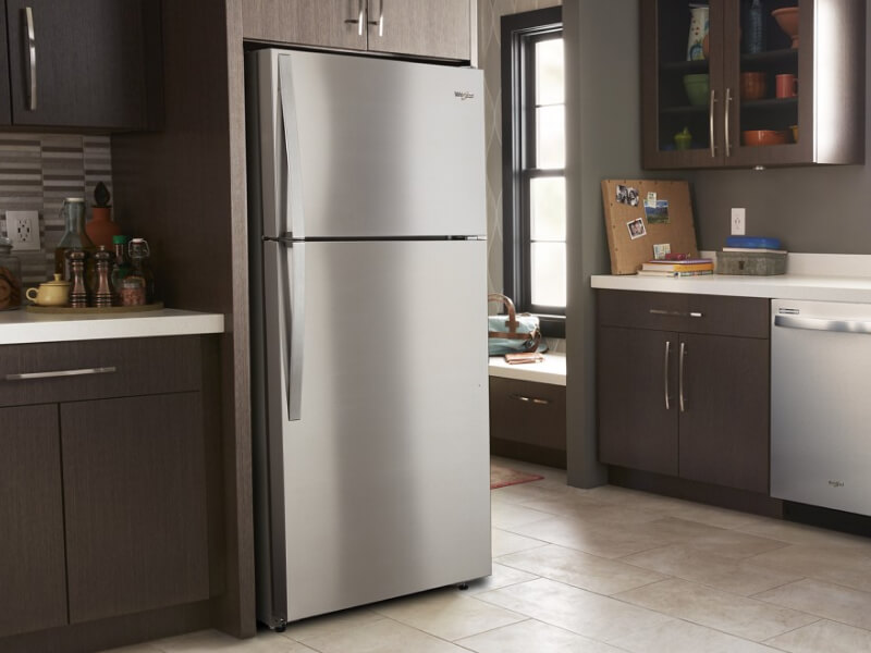 Stainless steel Whirlpool® Top-Freezer Refrigerator in brown cabinetry