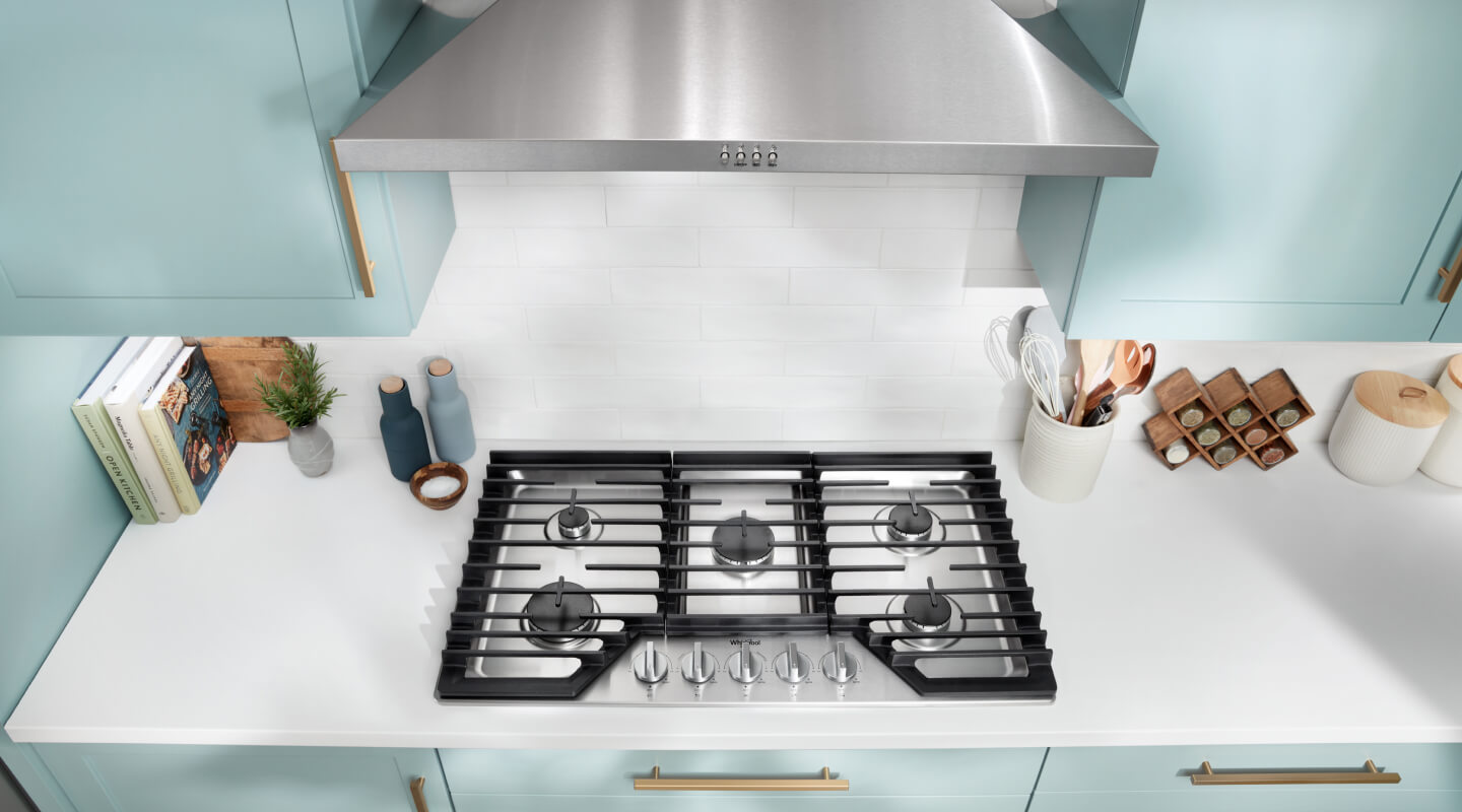 A bright white kitchen countertop with a cooktop installed