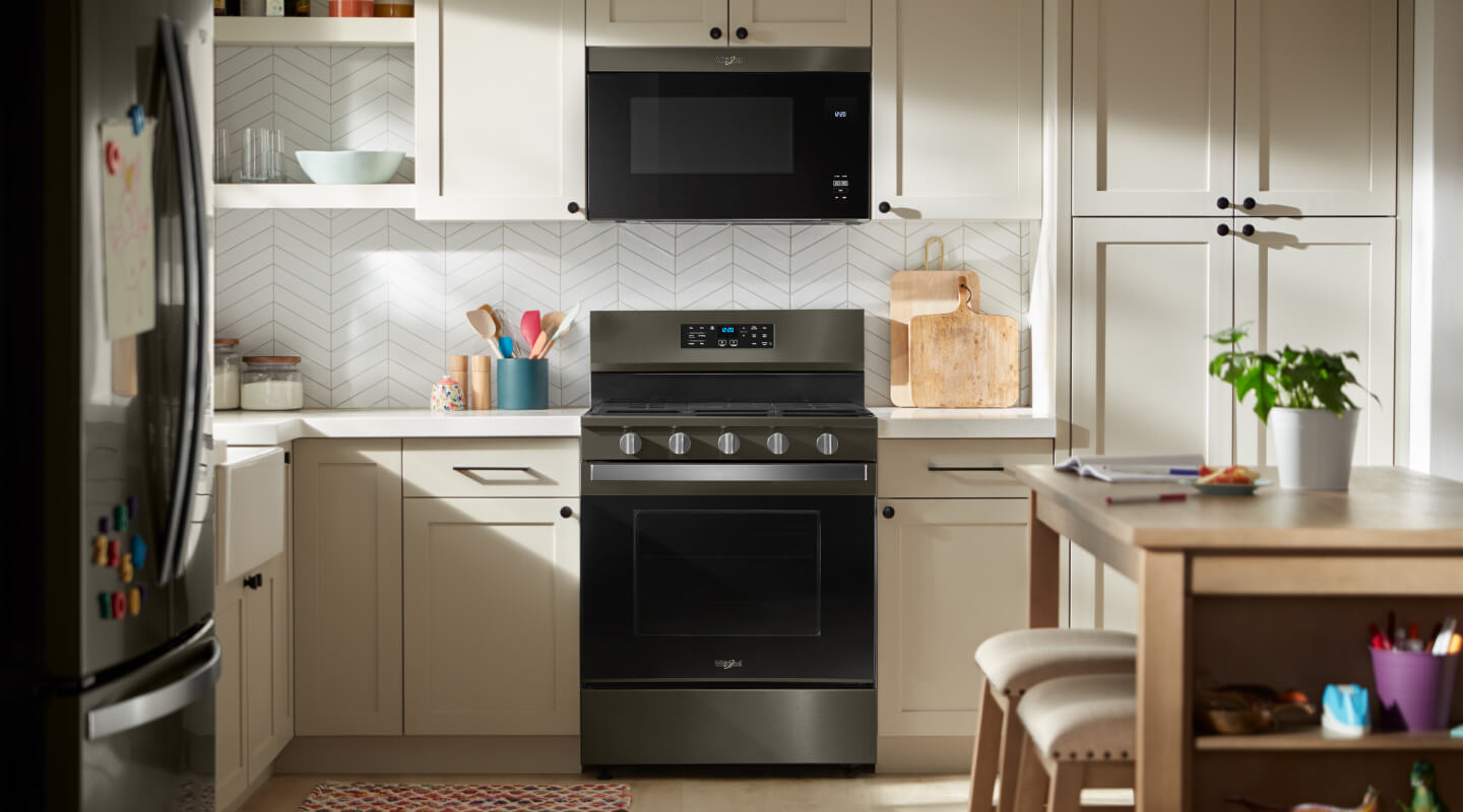 Gas stove with over the range microwave installed in a white kitchen
