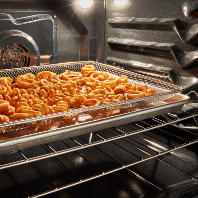 Curly fries inside an oven