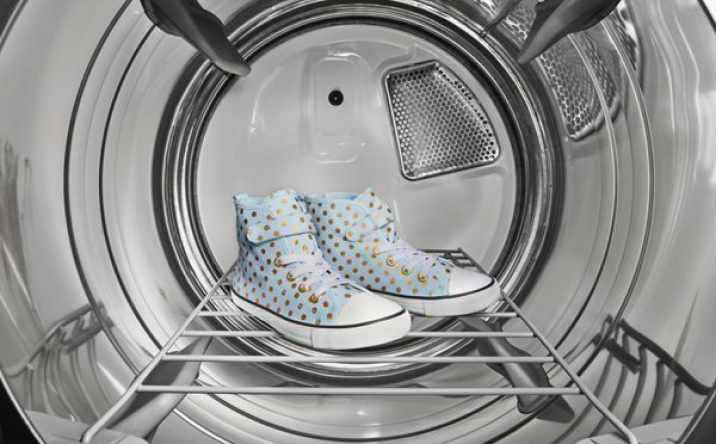 A pair of sneakers sitting on a rack inside a dryer