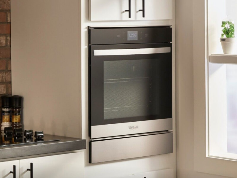 Single wall oven built into cream colored cabinets