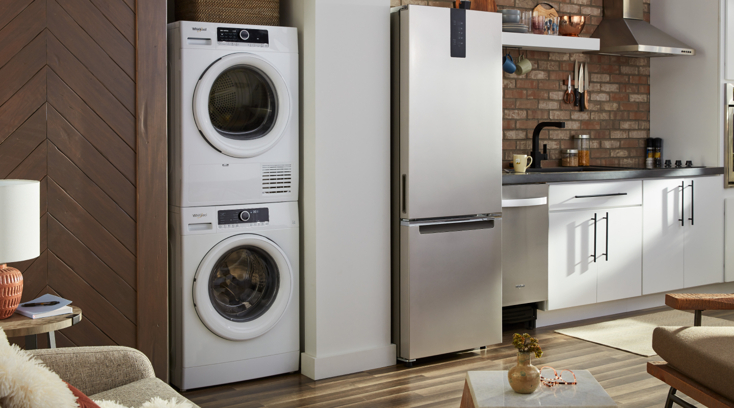 A Whirlpool® stacked washer and dryer in a modern kitchen A Whirlpool® stacked washer and dryer in a modern kitchen
