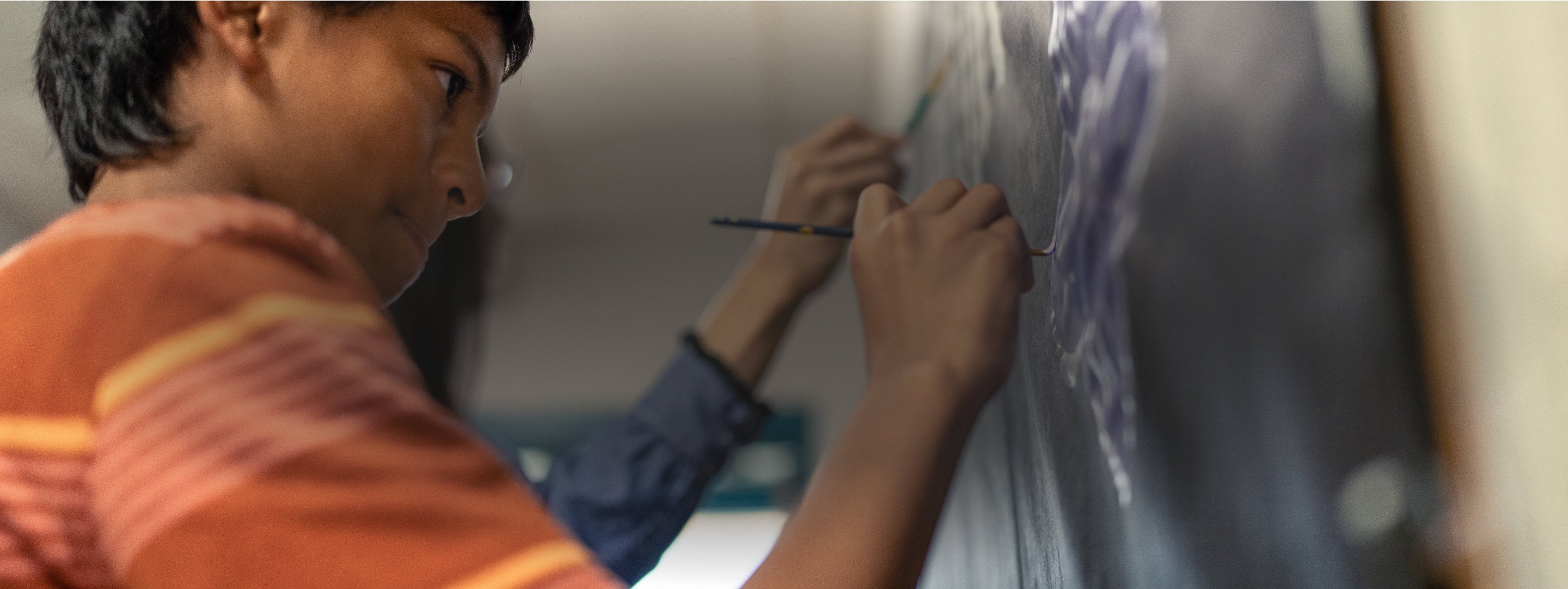 A child painting a heart on a backdrop