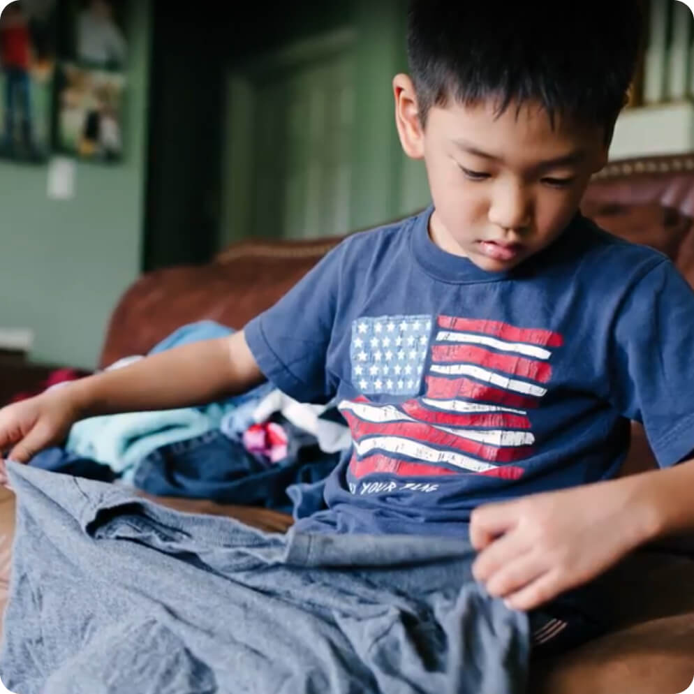 A child folding a T-shirt