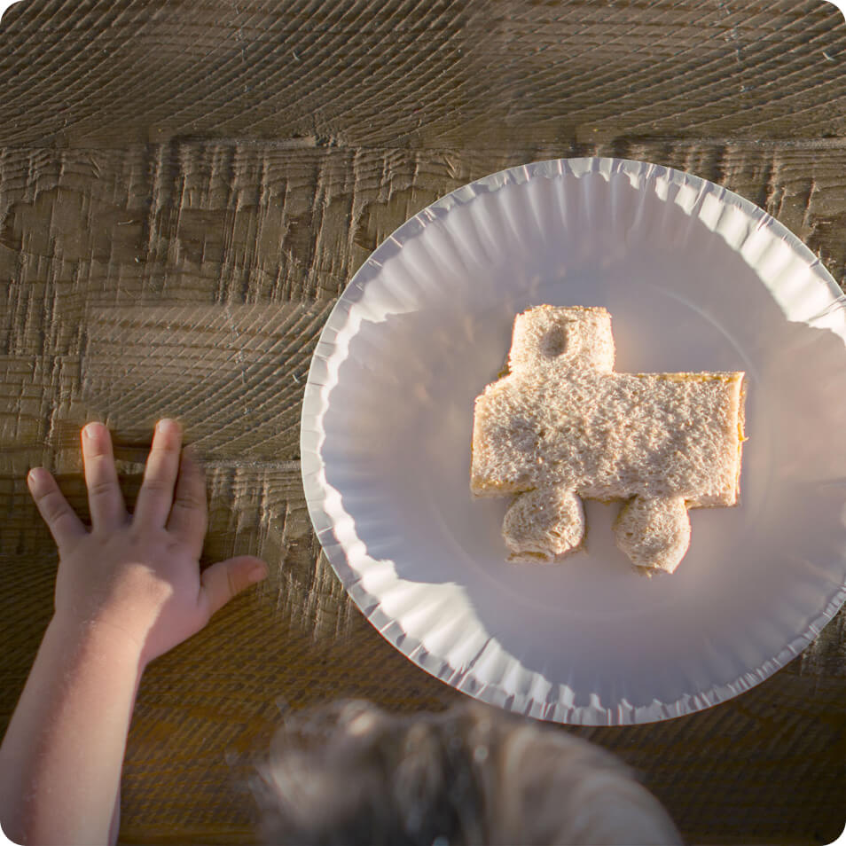 A child with a sandwich cut into the shape of a car