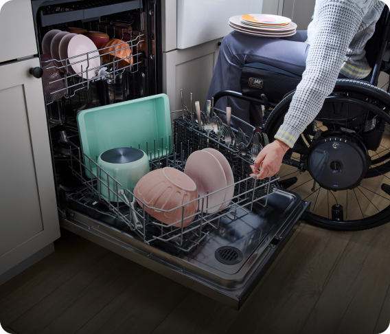 A person unloading dishes from the Spin&Load Rack