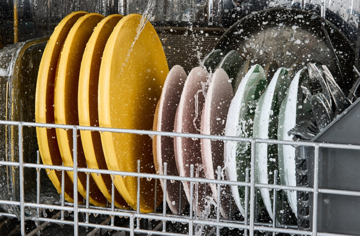 Muted colored plates being washed inside of a Whirlpool® Dishwasher