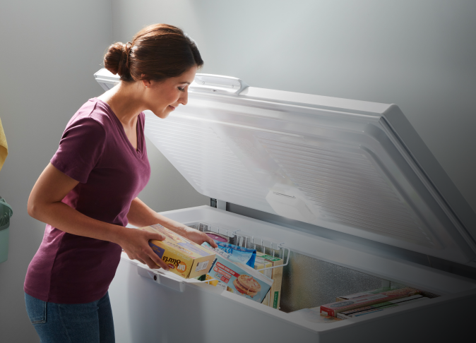 A person placing items into a Whirlpool® Deep Freezer