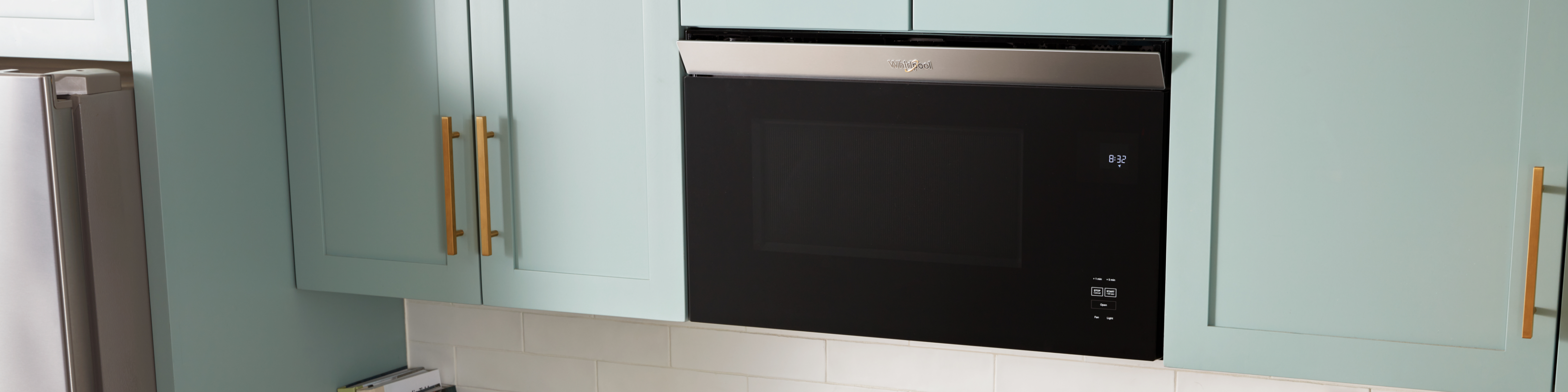 A Whirlpool® Low Profile Microwave in a sleek, white, modern kitchen