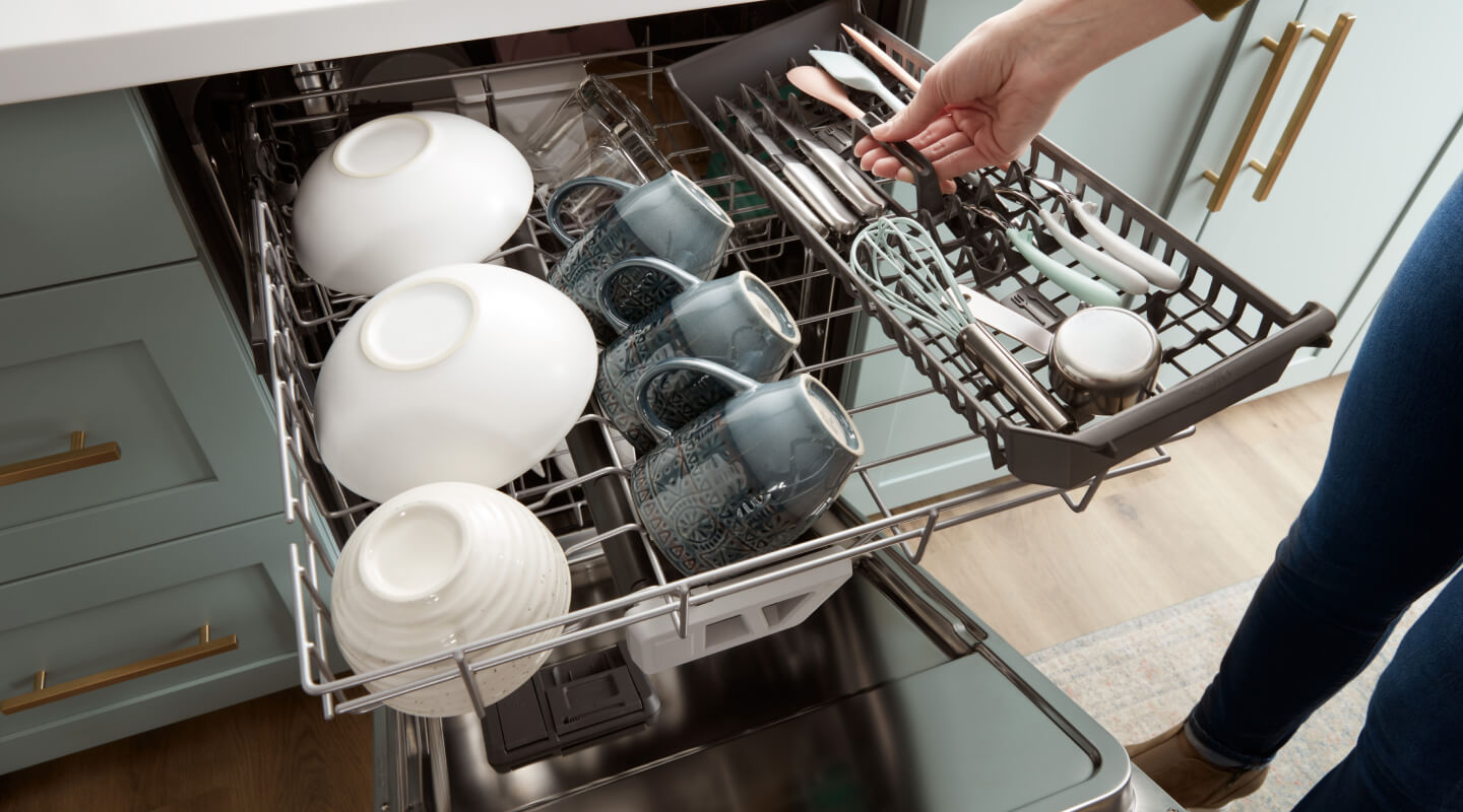 A person loading the third rack of a dishwasher A person loading the third rack of a dishwasher