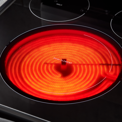 A red radiant heating element on an electric stove.