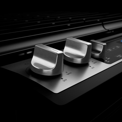 Stainless steel knobs on a gas range.