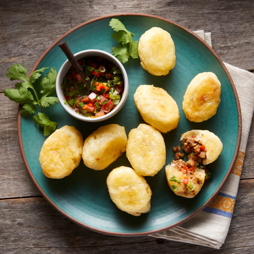 A plate of Carimañolas (baked cassava stuffed with beef and vegetables)