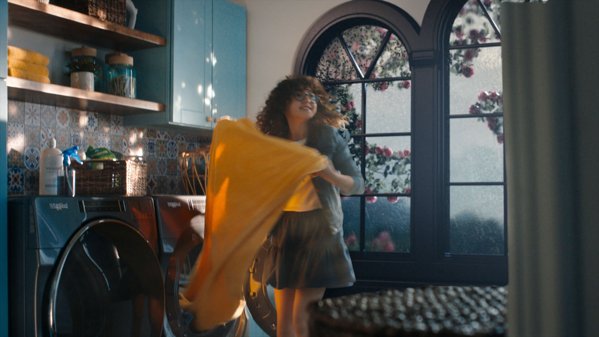 A woman taking a blanket out of a Whirlpool® Dryer