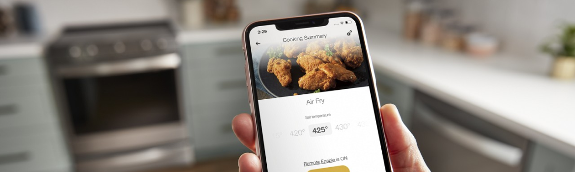 Hands using the Whirlpool® App to control their Whirlpool® Premium Electric Range