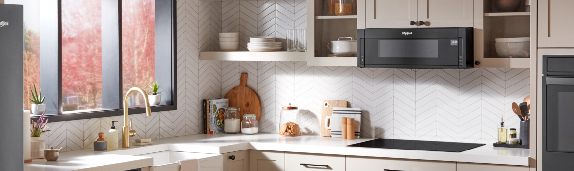 A black Whirlpool® Low Profile Over-The-Range microwave in a modern kitchen