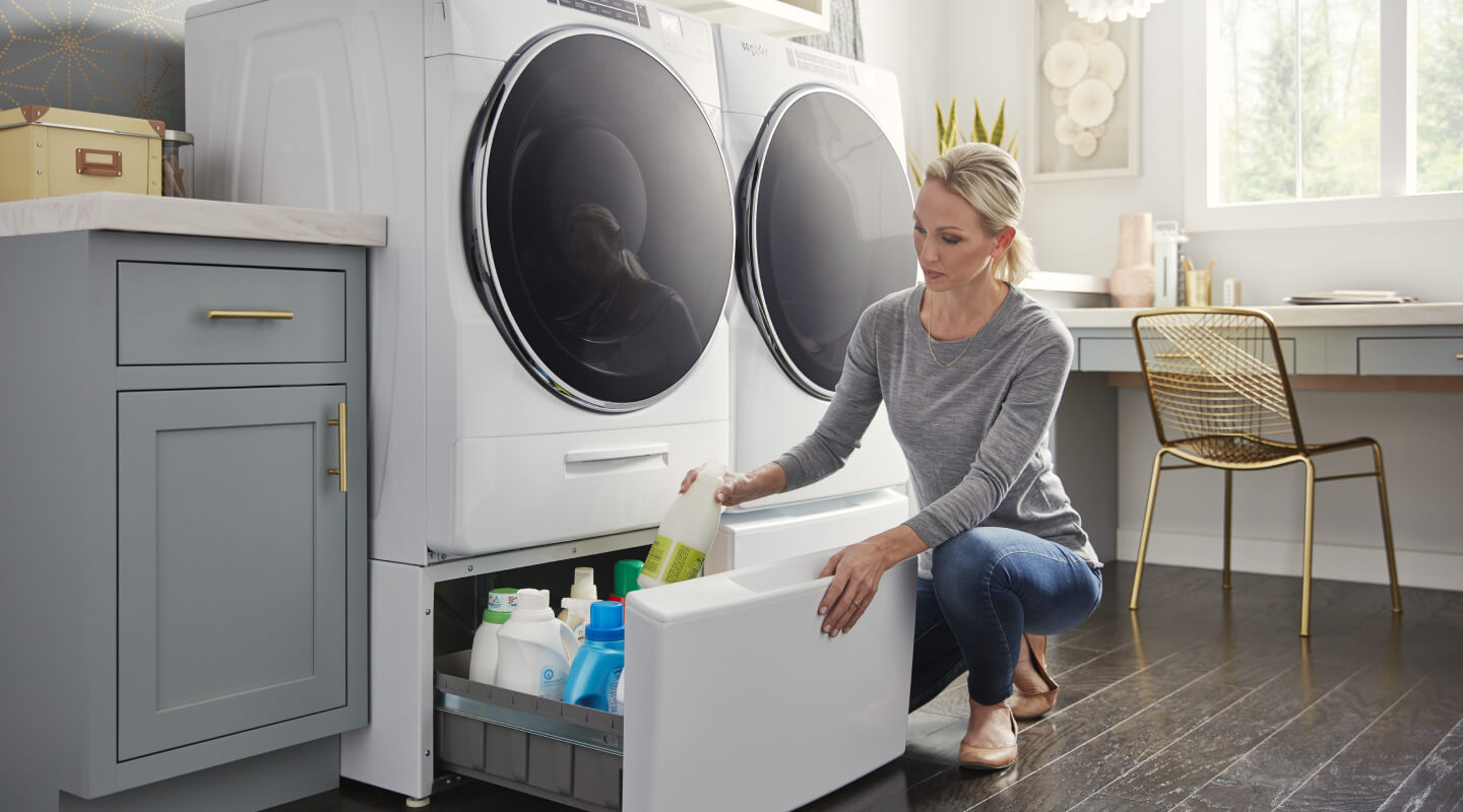Person putting items away in laundry storage pedestals