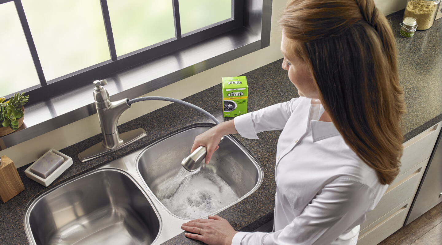 Person cleaning a sink Person cleaning a sink