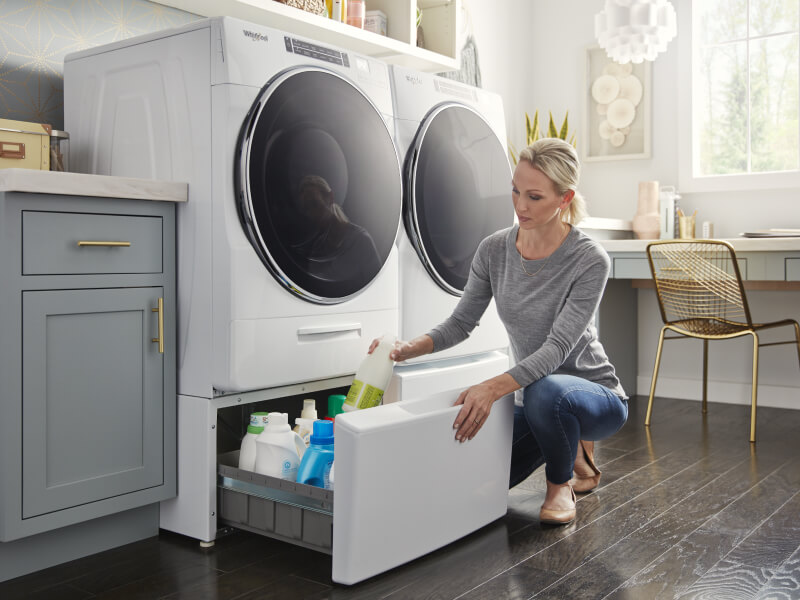 Person putting items away in laundry storage pedestals