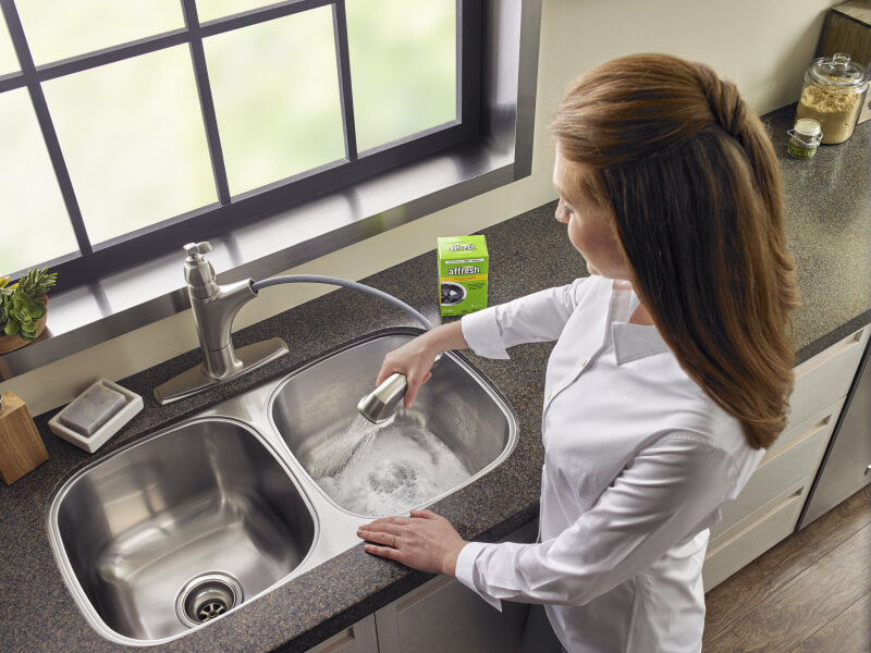 Person cleaning a sink Person cleaning a sink