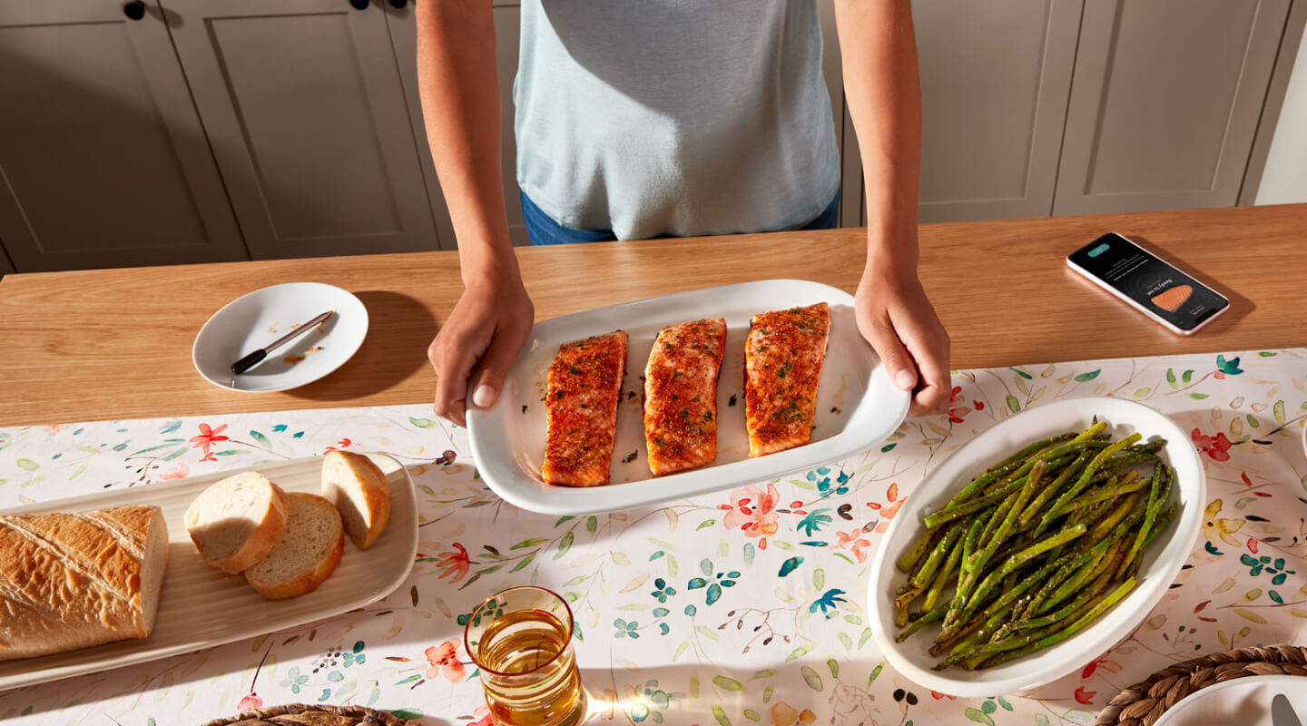 Birds-eye view of person holding platter with cooked salmon next to prepared bread and asparagus Birds-eye view of person holding platter with cooked salmon next to prepared bread and asparagus