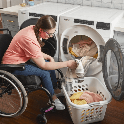 A person unloading clothes from a dryer