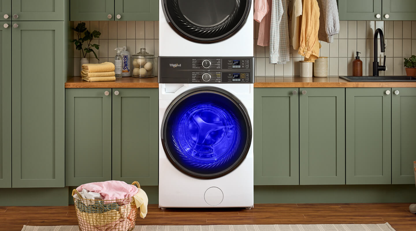 A stackable washer and dryer with the UV light on in a laundry room