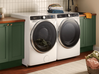 White front load washer and dryer set next to green cabinets