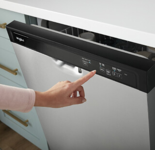 Person selecting a setting on a Whirlpool® front control dishwasher