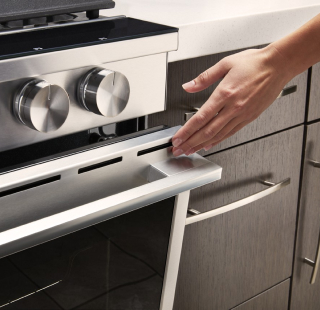 A person closing an oven door