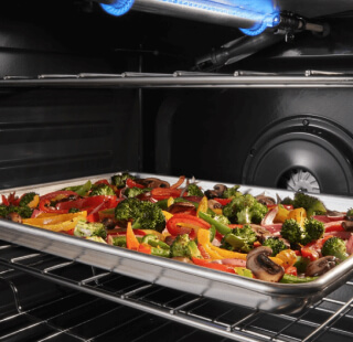 Sheet pan filled with vegetables inside an oven