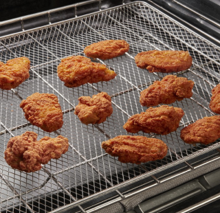 Chicken wings air frying on a tray