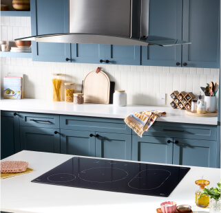 A Whirlpool® Induction Cooktop in a kitchen with blue cabinets