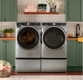 A Whirlpool® Laundry Set surrounded by dark green cabinetry
