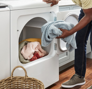 A person taking clothes out of a dryer