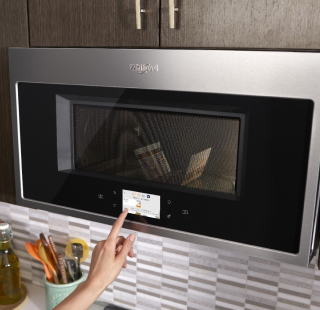 A person pressing buttons on a microwave