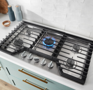 A cooktop with a blue flame simmering