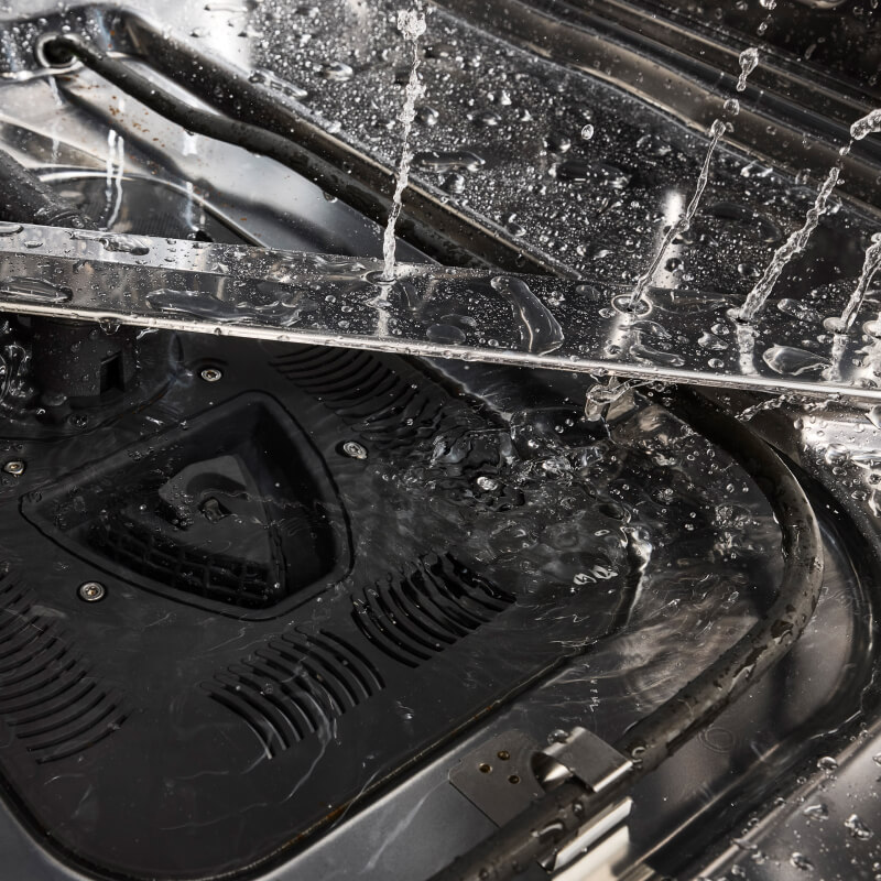 Closeup of dishwasher spray arm spraying water