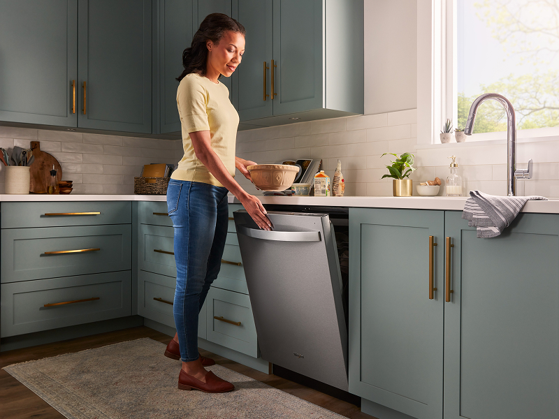 Person closing a top control dishwasher Person closing a top control dishwasher