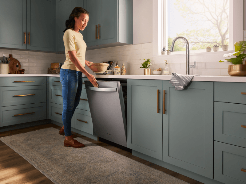 Person closing a Whirlpool® top control dishwasher Person closing a Whirlpool® top control dishwasher