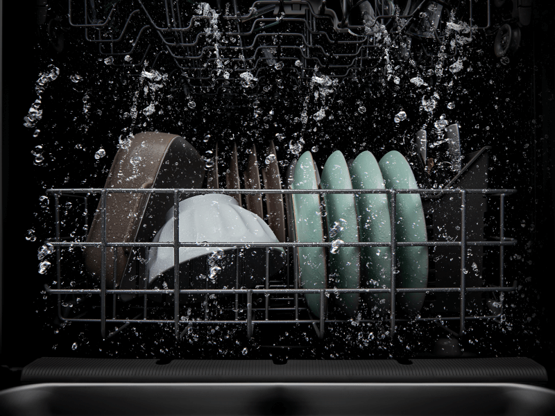 Dishes being cleaned in a dishwasher wash cycle