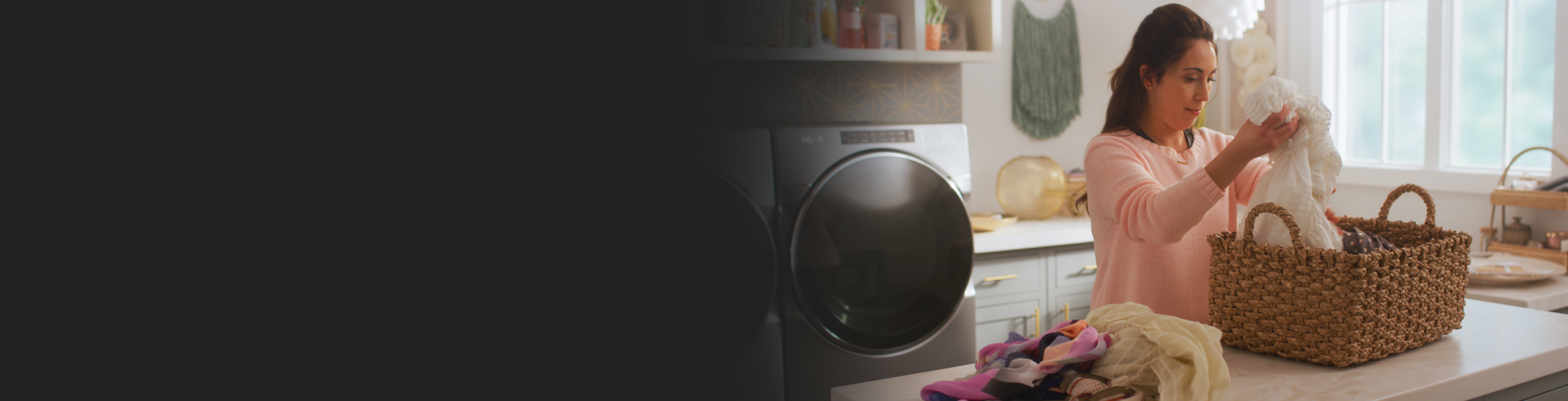 Woman picking up clothes from a laundry basket