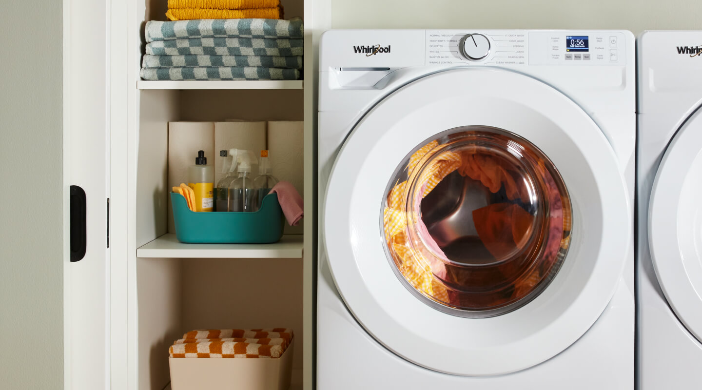 Whirlpool® Washing Machine in a laundry room with vertical shelves to the left of it