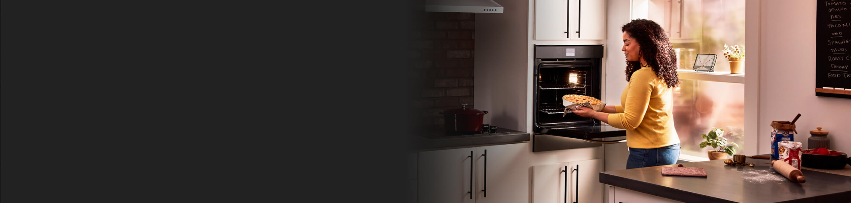 Person putting food in a wall oven