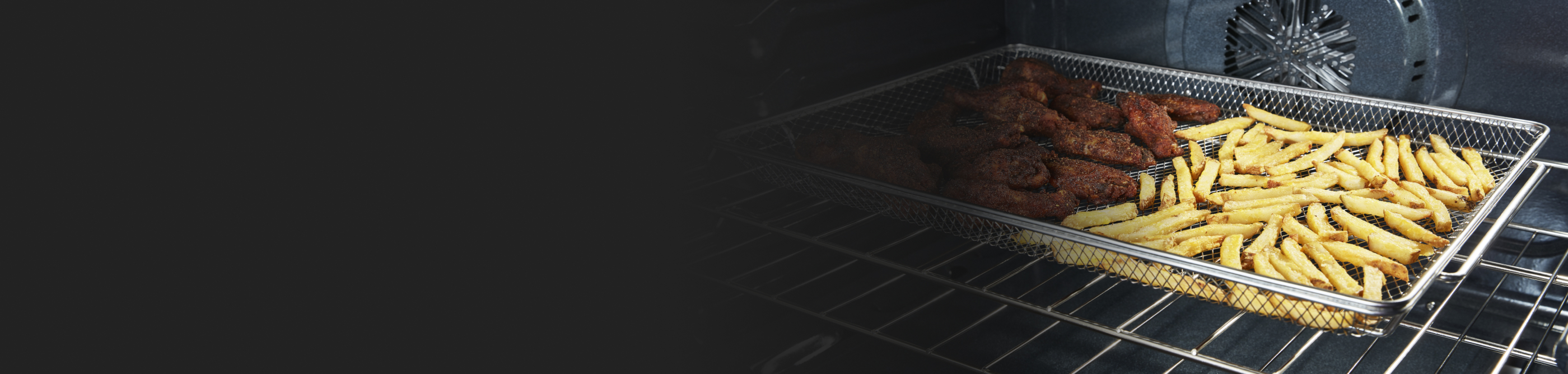 Inside oven with food cooking in an air fry basket.