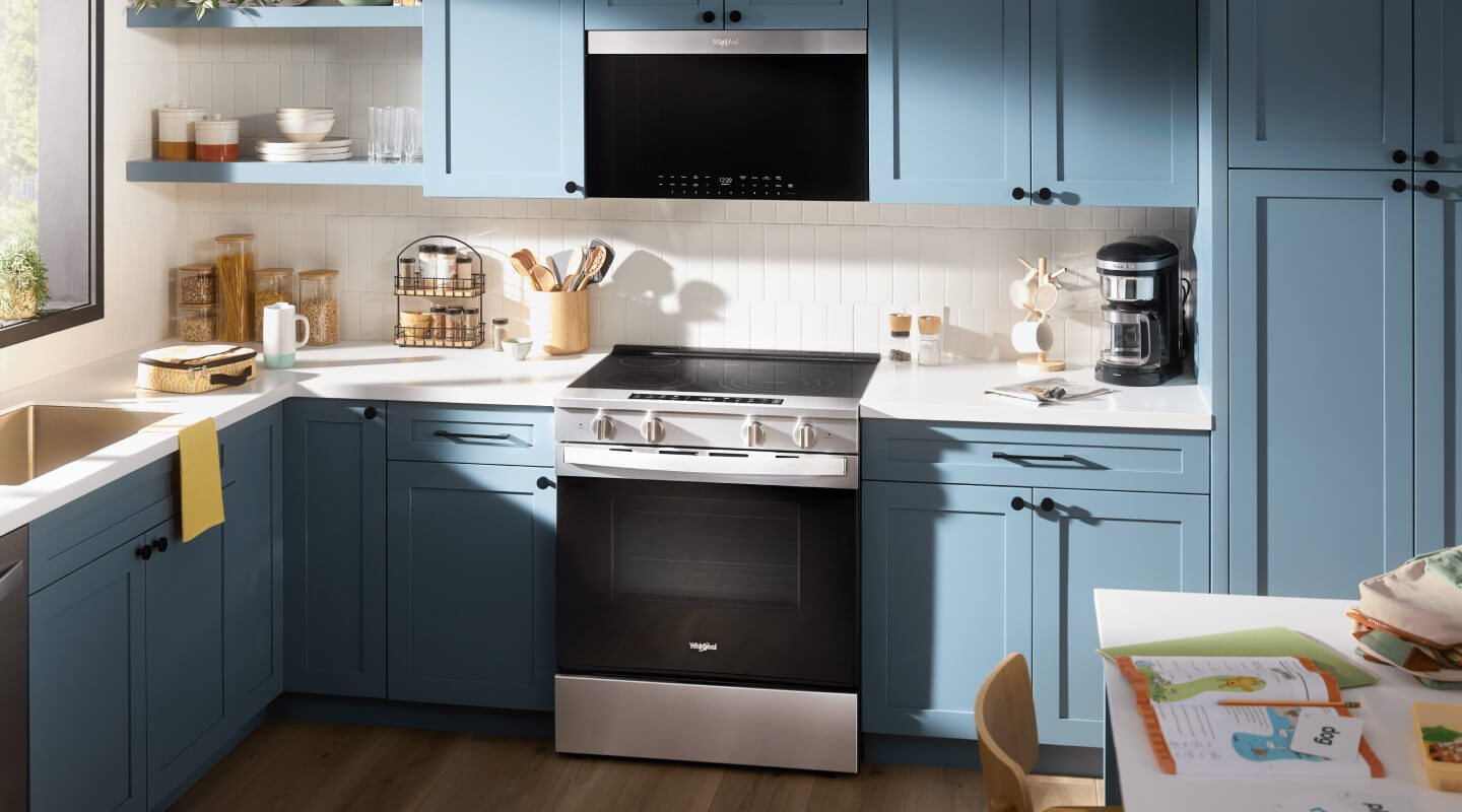 Whirlpool® Electric Range and Over-the-Range Oven in a blue kitchen