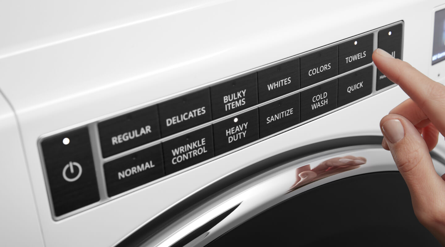 Person selecting a washing machine cycle