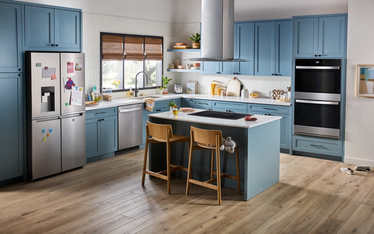 a beautiful kitchen in blue tones with stainless steel appliances and an island